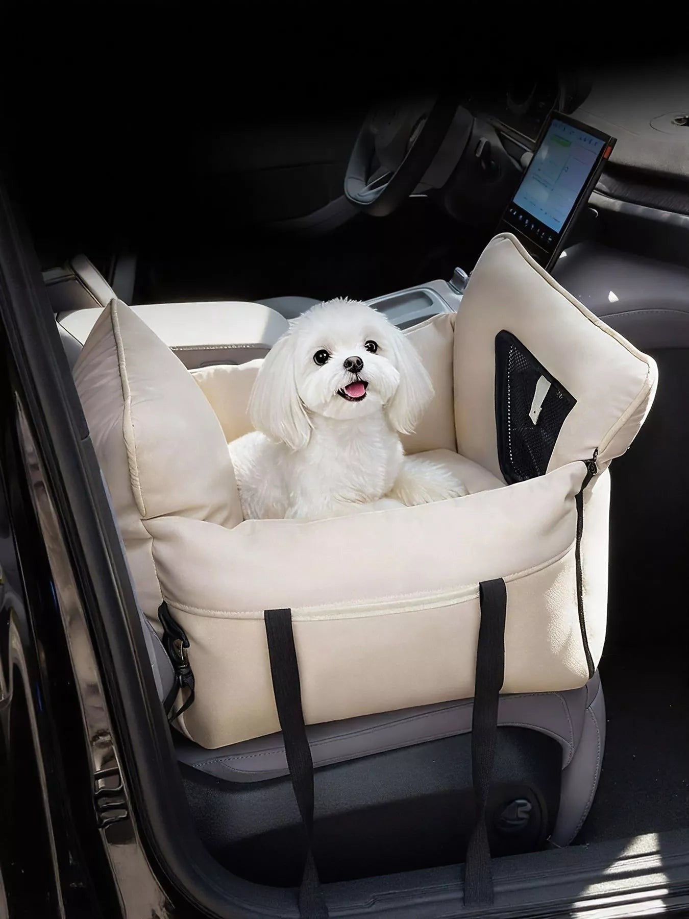 Little Pets Club beige pet car seat bed with a small white dog sitting inside. Features adjustable straps and a mesh pocket.
