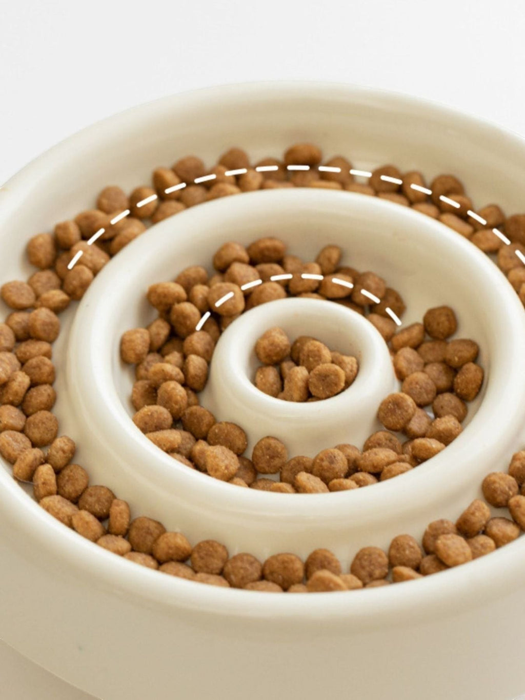 Little Pets Club cream ceramic slow feeder dog and cat bowl with spiral pattern filled with kibble.