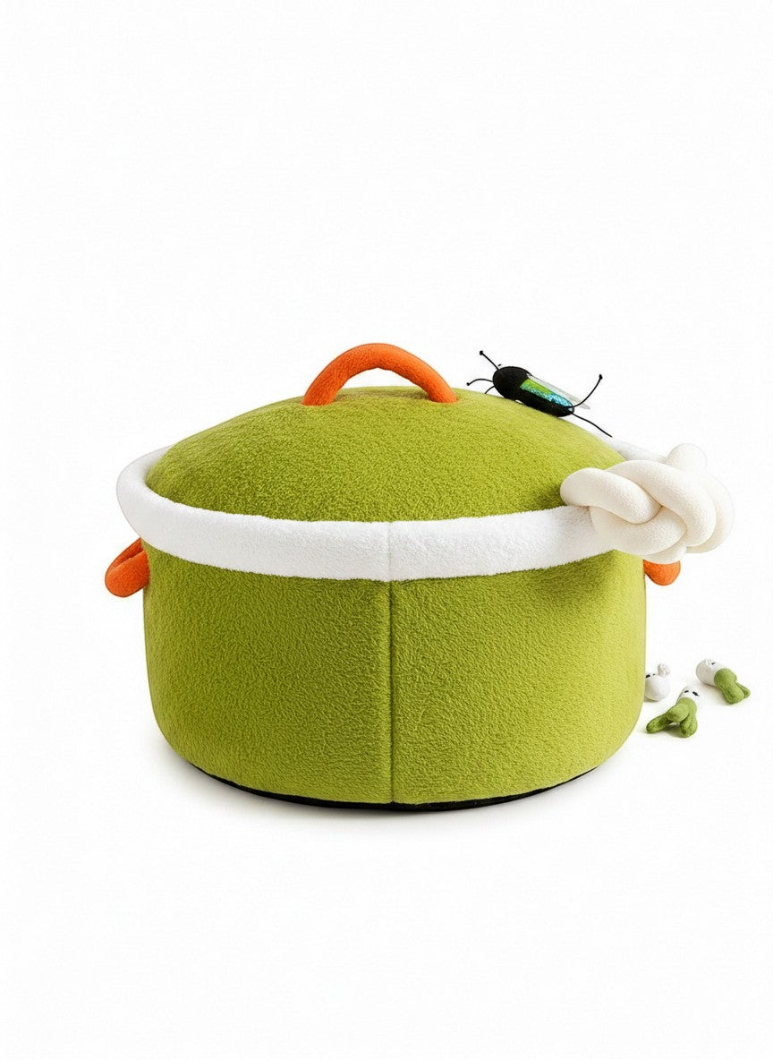 The Cozy Critter Cave pet bed by little pets club is a green, plush, semi-enclosed hideout with orange handles and a white trim.