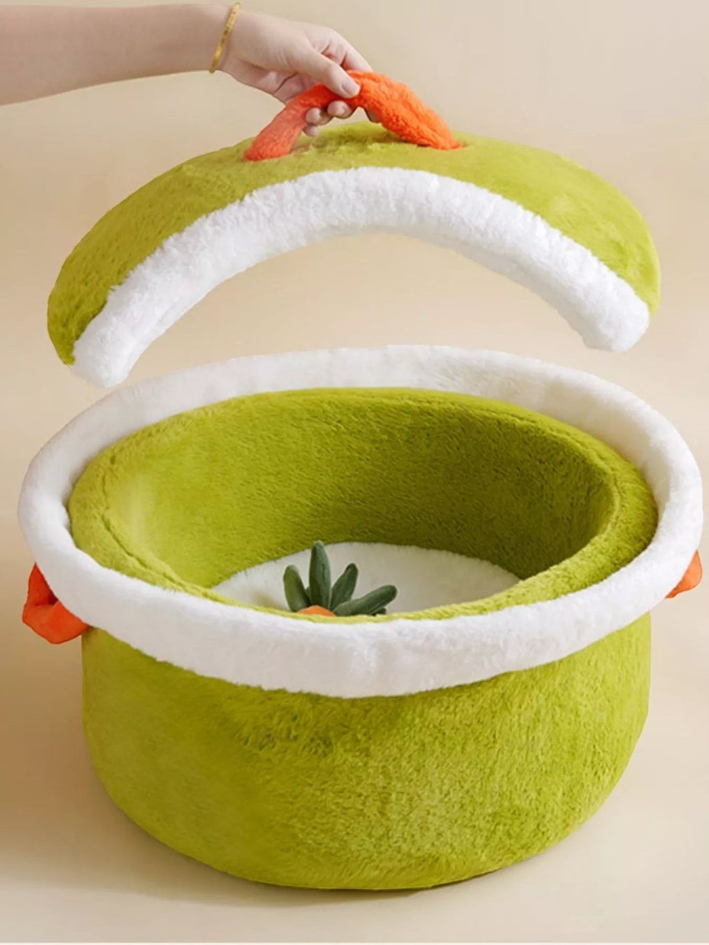 The Cozy Critter Cave™ pet bed by little pets club is a plush, semi-enclosed green hideout with a white trim and orange carrot detail.