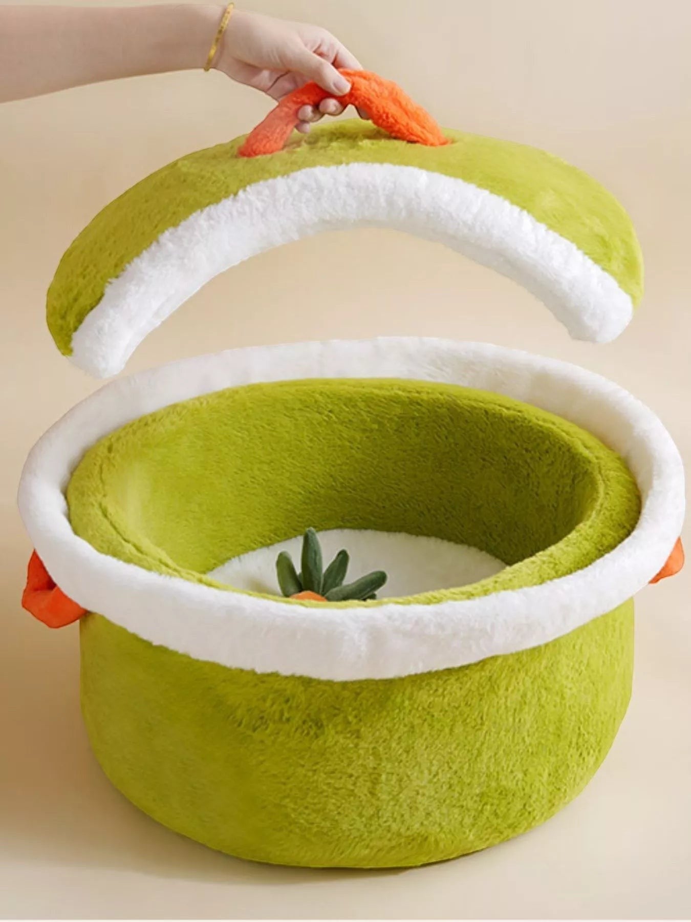 The Cozy Critter Cave™ pet bed by little pets club is a plush, semi-enclosed green hideout with a white trim and orange carrot detail.