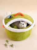 The Cozy Critter Cave™ pet bed by little pets club is a plush, semi-enclosed green hideout with orange and white trim. Features a playful bug toy.