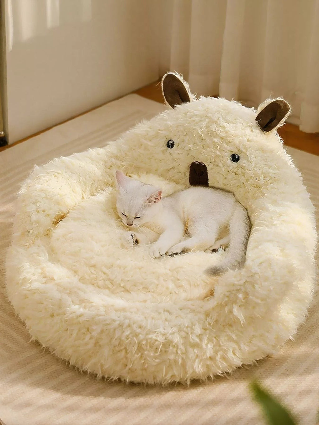 Little Pets Club cream plush bear-shaped pet bed with a white cat sleeping inside. Features raised edges for support.