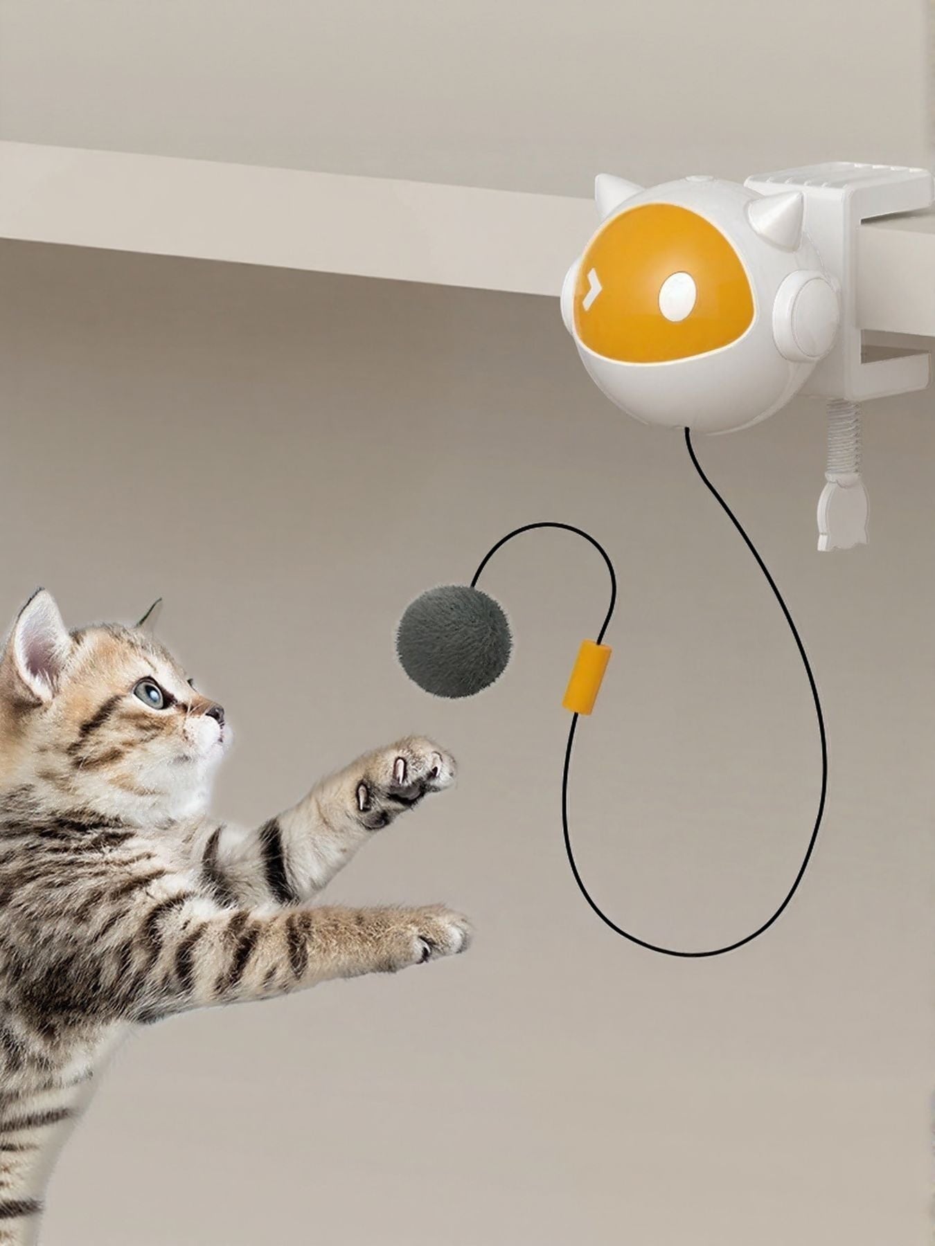 Little Pets Club interactive cat teaser toy with a grey pom-pom ball, white and orange robot design, attached to a shelf.