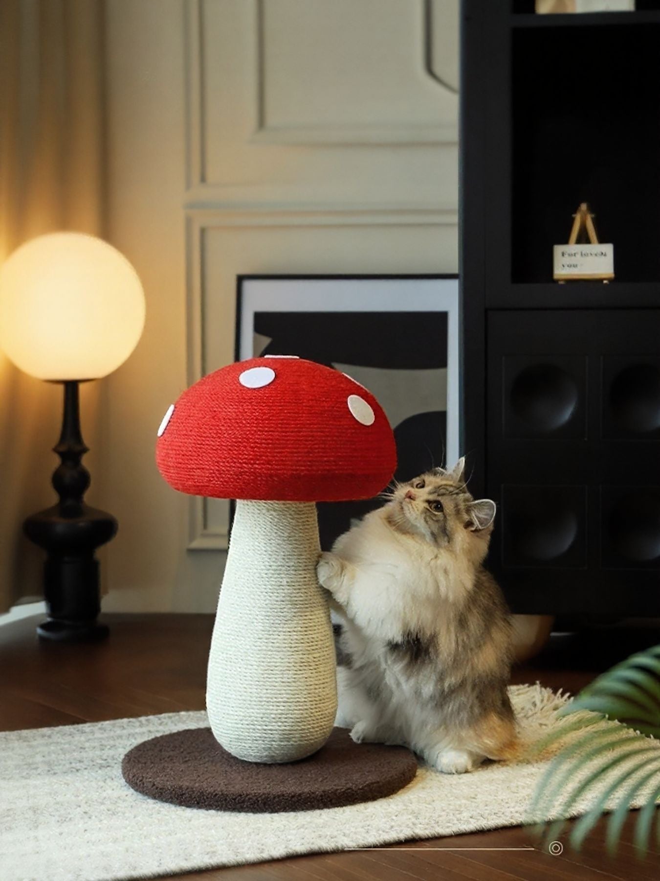 Little Pets Club mushroom cat scratching post with red cap and white spots, natural fiber stem, and a fluffy cat playing.