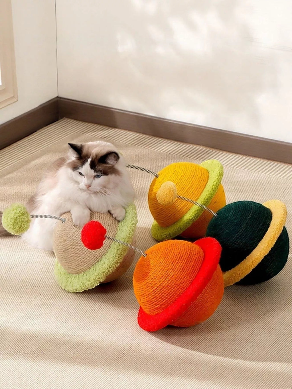 Little Pets Club Orbit Bounce Planet Cat Toy with spring pom poms and scratching surface. Available in orange, yellow, and green.