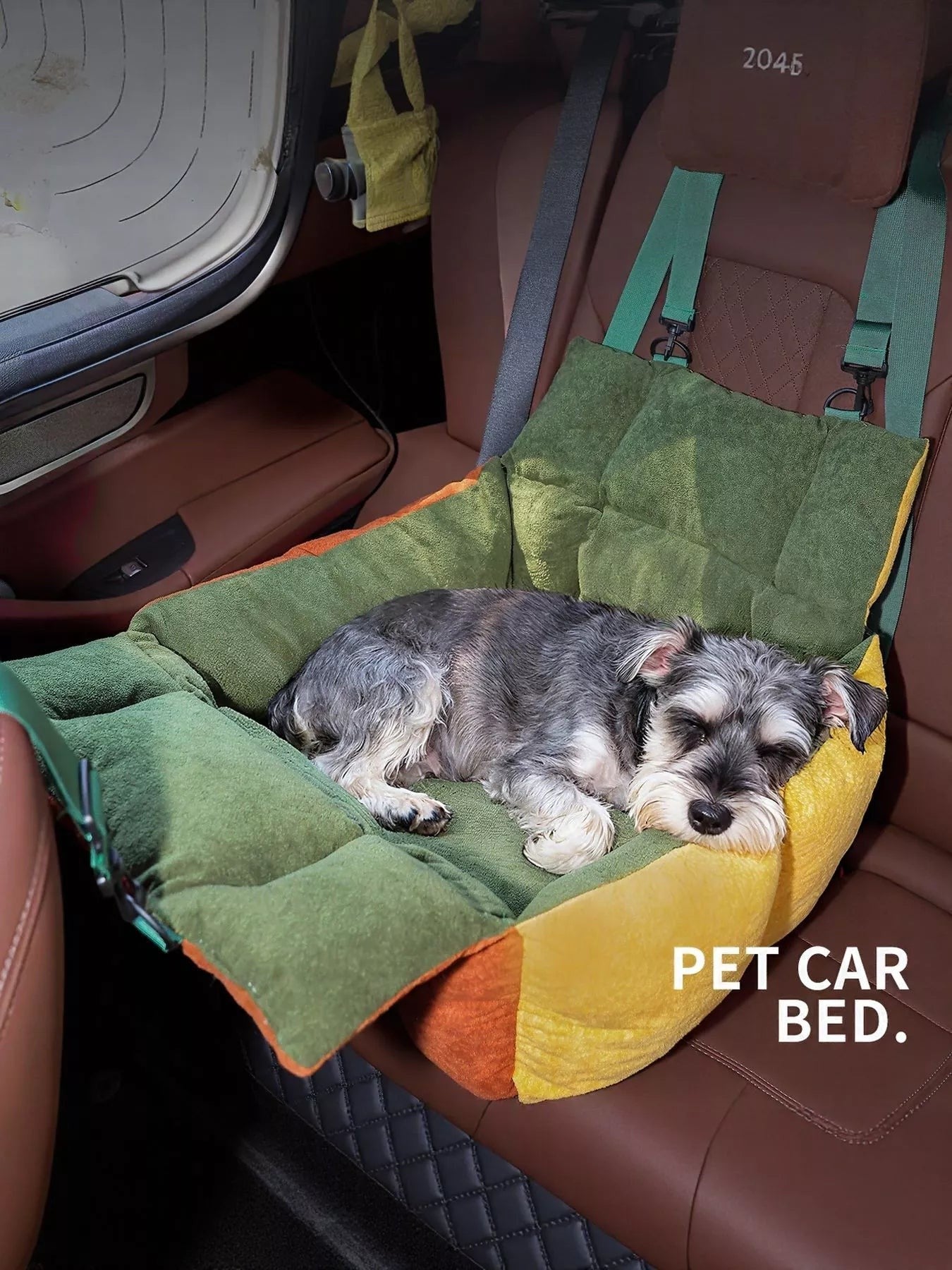 Little Pets Club green and yellow pet car seat bed with a small dog sleeping comfortably. Adjustable straps for secure attachment.