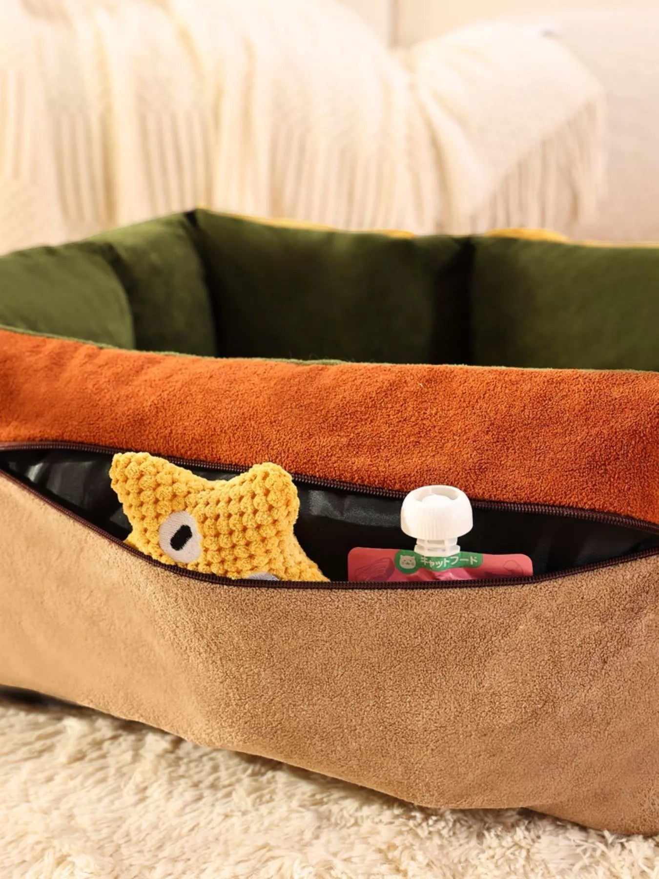 Little Pets Club tan pet car seat bed with orange and green trim. Features a zippered pocket with a yellow toy and food pouch.