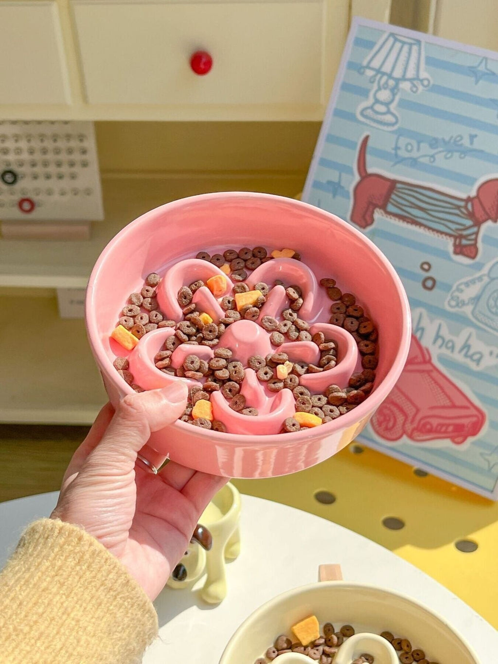 Little Pets Club pink ceramic flower slow feeder pet bowl filled with kibble, designed for cats and small dogs to eat slower.