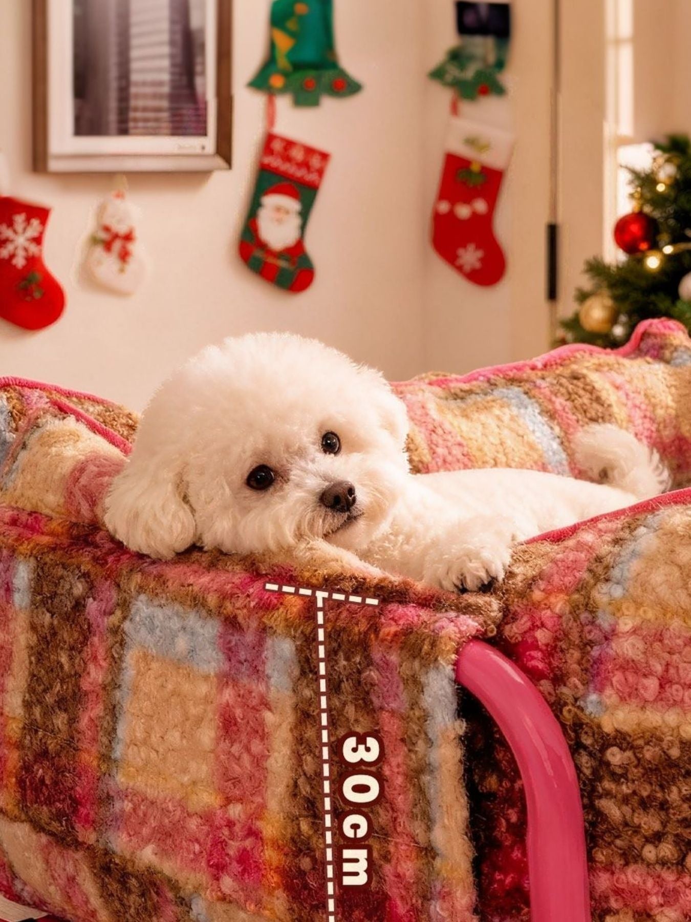 Little Pets Club Retro Plaid Snuggle Sofa with a white Bichon Frise dog resting on it. The sofa has raised sides and a cozy plaid pattern in pink, brown, and blue.