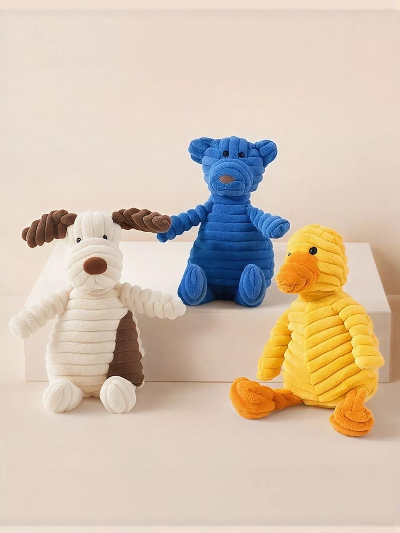Little Pets Club plush corduroy dog, bear, and duck toys in white, blue, and yellow. Ribbed texture, huggable stuffing.