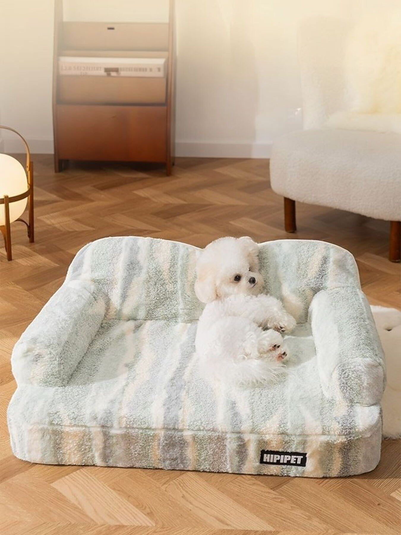 Little Pets Club plush pet sofa bed in light green and grey tie-dye pattern with two small white dogs lounging.