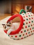 Little Pets Club plush enclosed cat bed with red trim, polka dot design, and green carry handle. A fluffy cat sleeps inside.