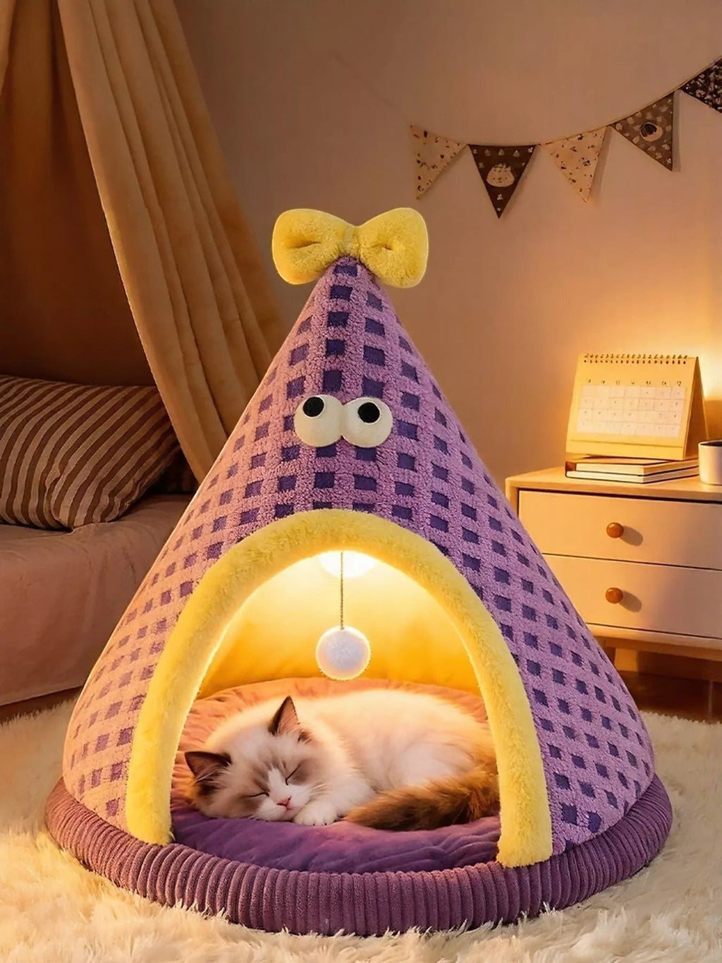 Little Pets Club purple plush cat tent bed with yellow trim and bow, featuring a cute face and hanging toy. A fluffy cat sleeps inside.