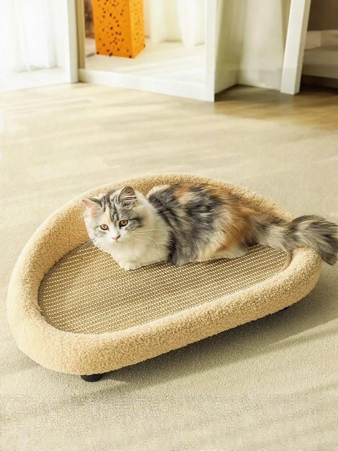 Little Pets Club tan woven cat lounge bed with sisal scratching surface and fluffy trim. A calico cat rests on the bed.