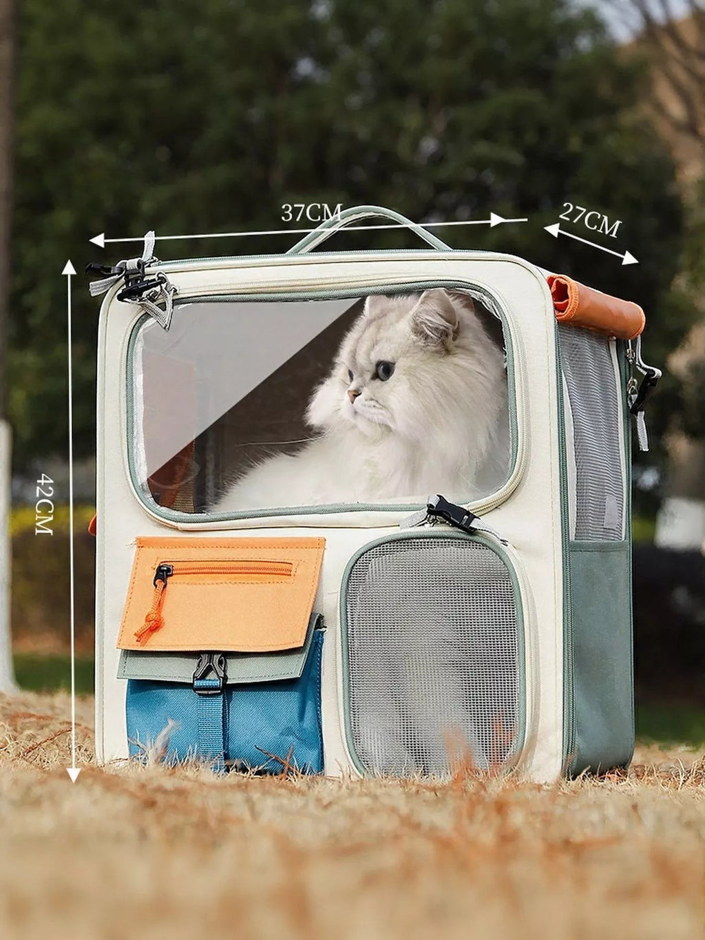 Little Pets Club wheeled pet carrier in cream and green with a large clear window and multiple colorful pockets. A white cat looks out from the window.