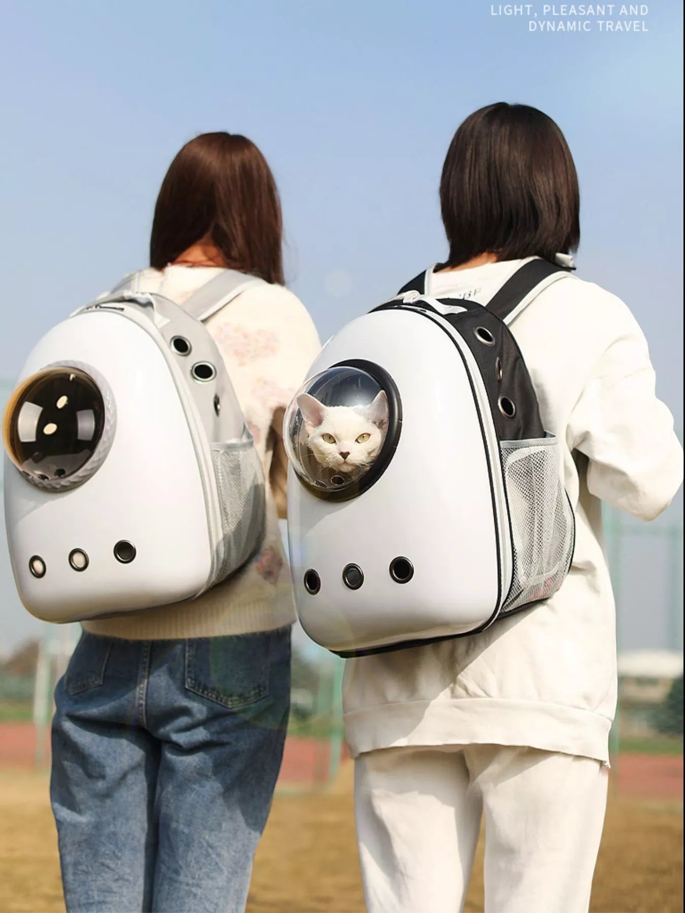 Little Pets Club white space capsule pet carrier backpack with transparent dome, mesh sides, and ventilation holes, worn by a person outdoors.