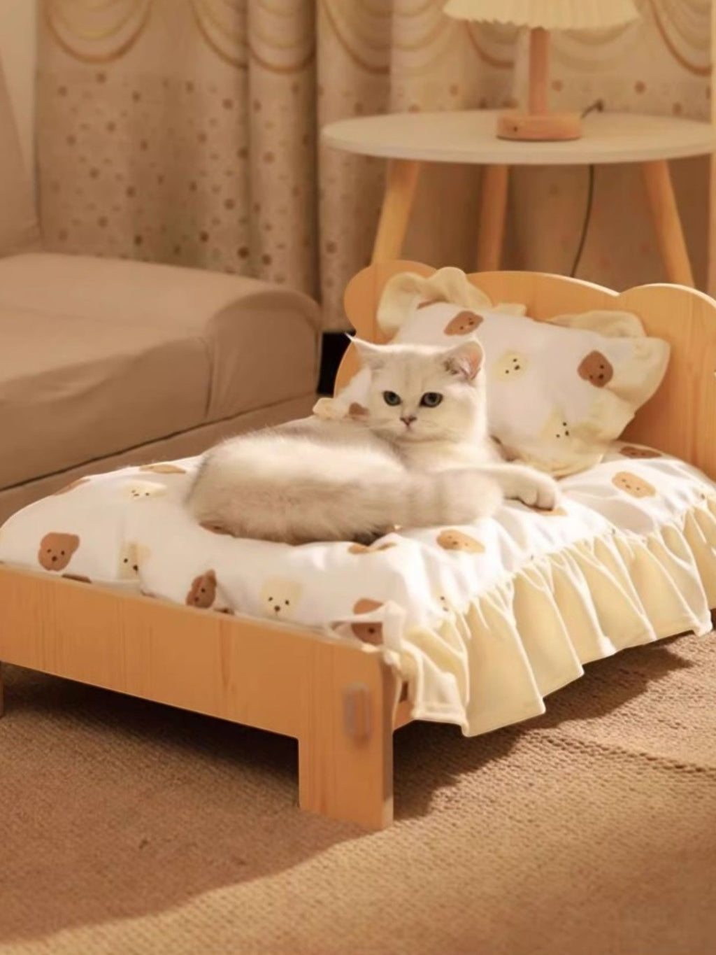 Little Pets Club natural wood mini pet bed with white teddy bear print bedding and a white cat lounging on it.