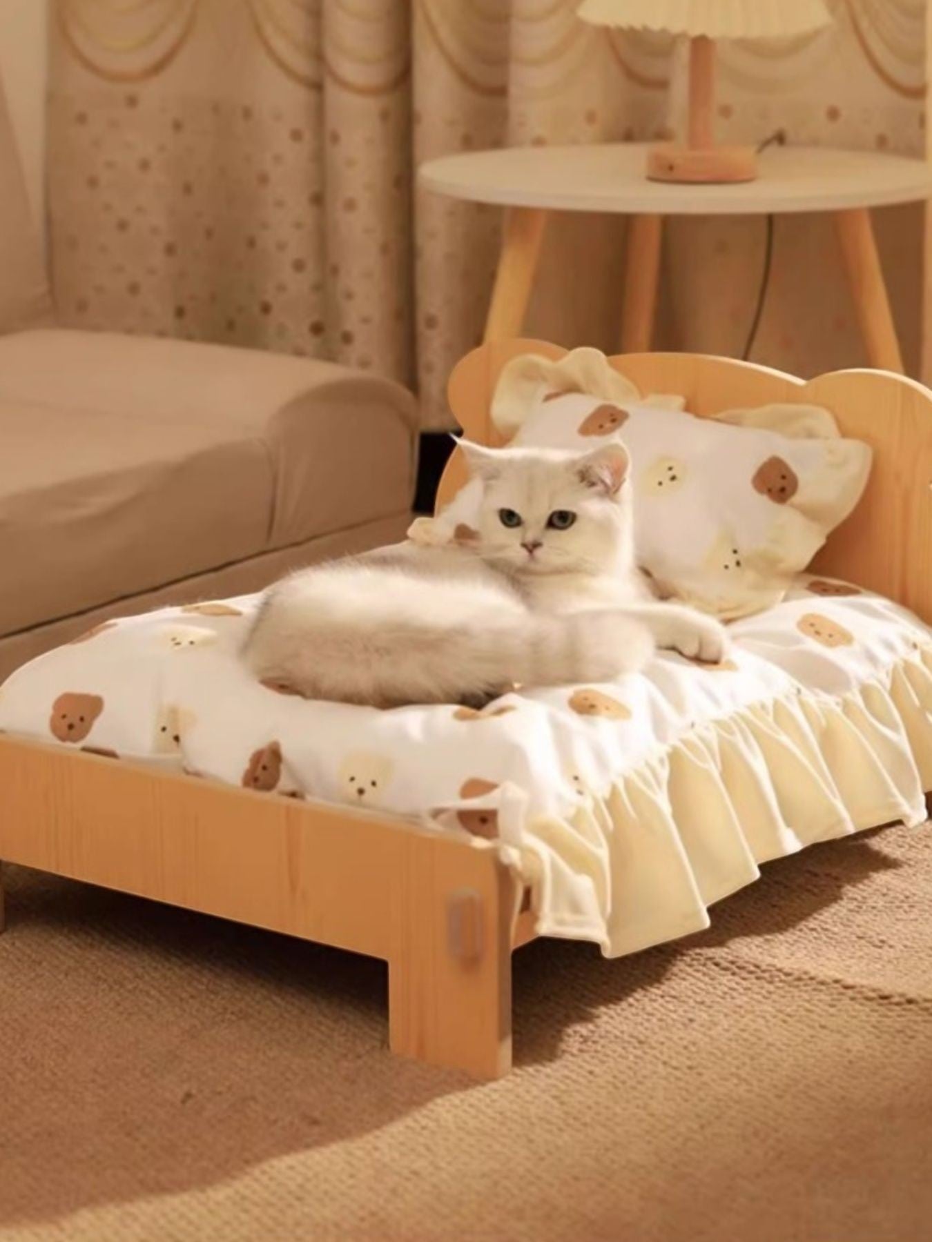 Little Pets Club natural wood mini pet bed with white teddy bear print bedding and a white cat lounging on it.