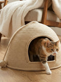 little pets club natural woven dome cat bed with plush cushion, a tabby cat is entering the hideaway.
