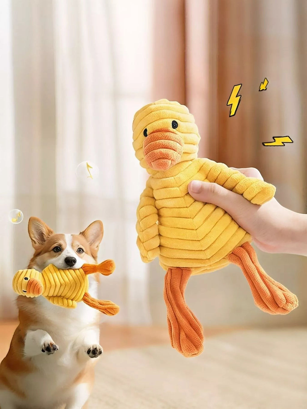 Little Pets Club yellow corduroy duck plush toy with orange feet, held by a hand and carried by a corgi dog.