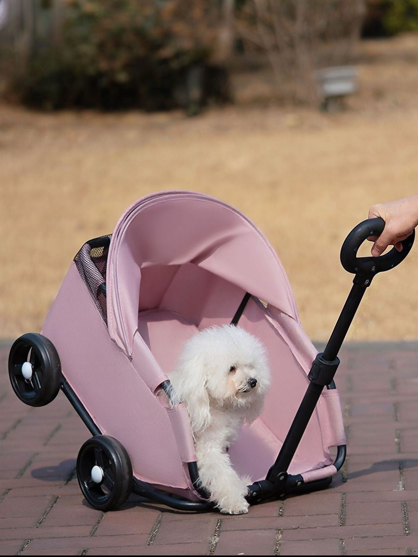 Little Pets Club pink pet stroller with a white bichon frise dog inside, featuring a canopy and smooth-rolling wheels.