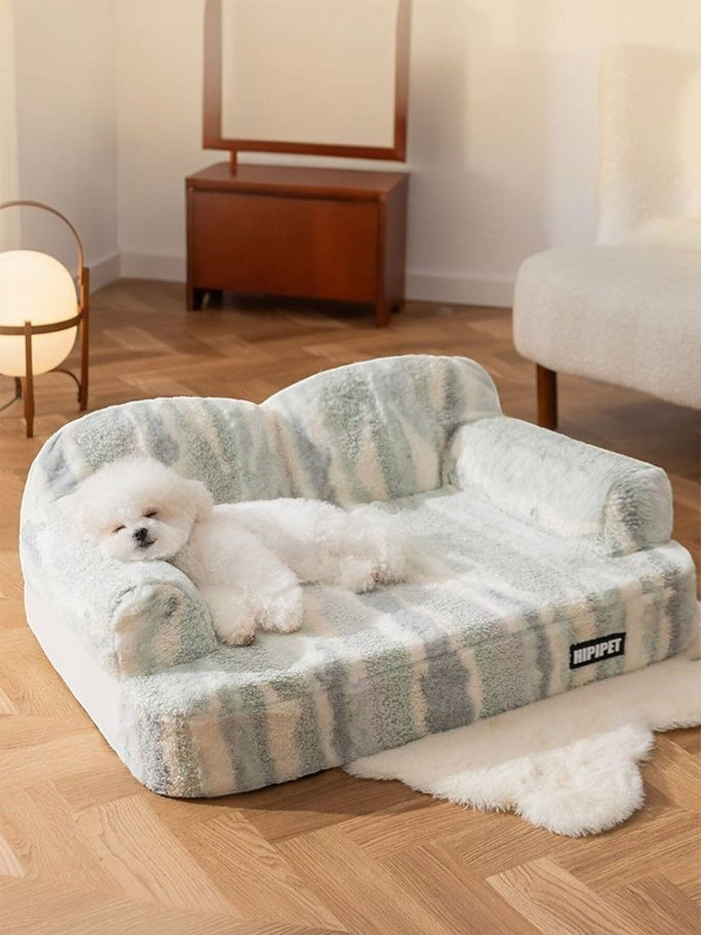 Little Pets Club ultra-soft plush pet sofa bed in a green and white stripe pattern, featuring a white Bichon Frise dog resting.