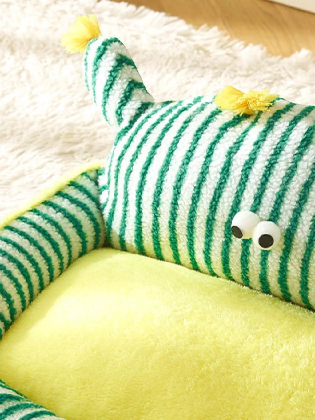 Little Pets Club green and white striped plush pet bed with yellow interior and googly eyes.